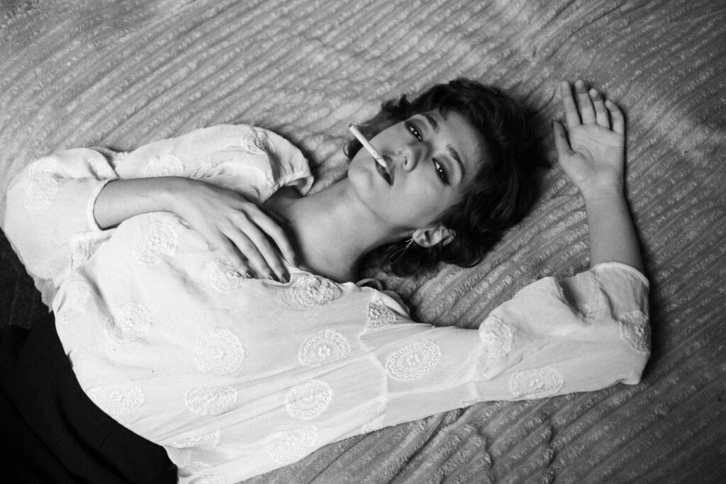 pexels-photo-30497423-30497423 A dramatic black and white portrait of a woman smoking, captured indoors in Tehran, Iran.